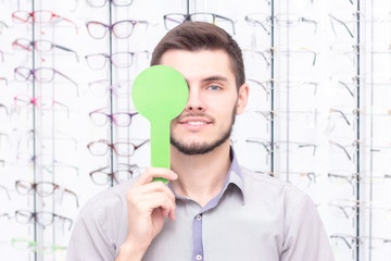 Ophthalmologist examines the young man in the clinic. Consultation of an ophthalmologist. Medical...