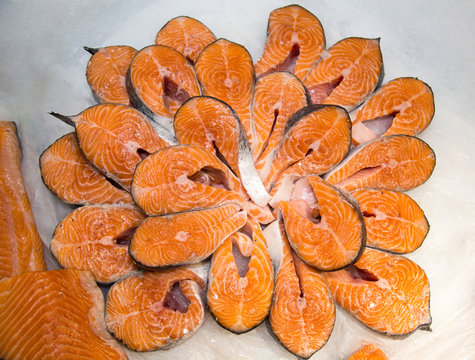 Salmon steaks chilled on a background of white ice. Seafood, fish, useful products.