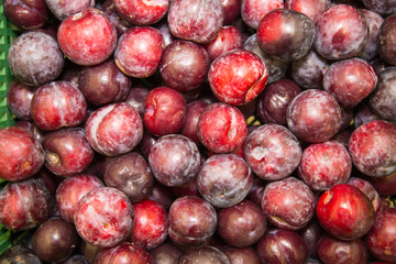 Red plum in a plastic box. Selective focus. Fruits, berries, useful products.