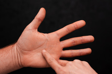 Fortune teller reading male palm on black background. Palmistry or chiromancy concept. Close-up