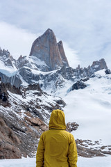 A hiker with a yellow jacket on the base of Fitz Roy Mountain in Patagonia, Argentina
