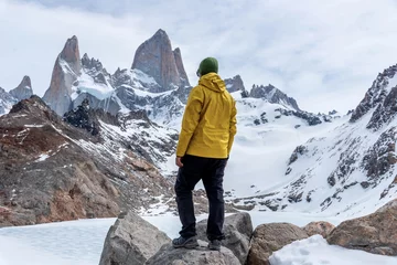 Papier Peint photo Fitz Roy A hiker with a yellow jacket on the base of Fitz Roy Mountain in Patagonia, Argentina