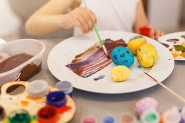 Easter eggs in nest on color wooden background