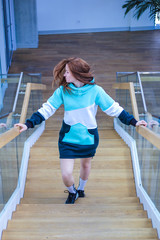Girl in long hoodie. Three colors: mint, dark green and white. Warm bright sweater. Urban city style. Outdoor sportswear for snowboarding.