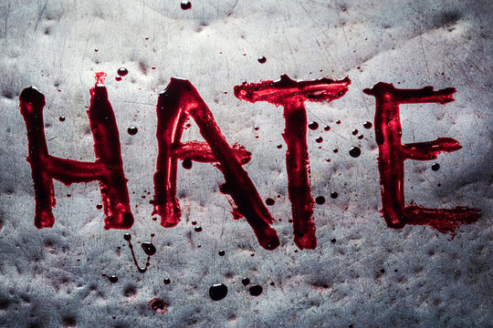 The word hate painted by blood on a metal table