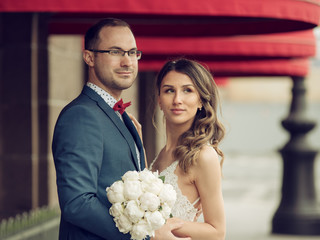 Just married couple is standing on the street and tenderly hugging each other. They are in love.