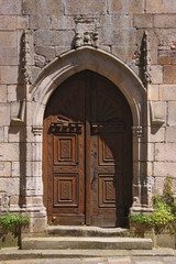 Fototapeta na wymiar Gothic church gate with closed wooden renaissance door at Saint Sauveur basilica in Dinan city, Brittany in France