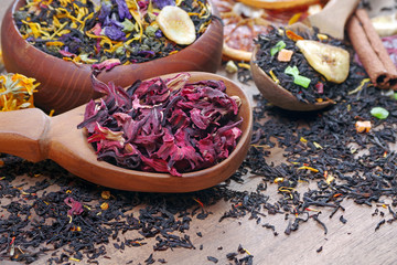 Assortment of dry tea. different varieties of tea on a wooden table. blended tea with flower...