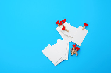 white empty paper rectangular business cards on decorative clothespins with a red heart lie