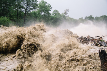 Strong flow of water at a hydroelectric dam. The dam of a mountain river after heavy rains