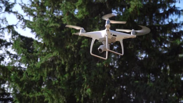 Drone Quadrocopter with camera Flying on forest background. Close-up shot video. Aircraft technology