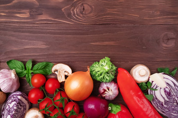 Healthy clean eating layout, vegetarian food, diet nutrition concept. Various fresh vegetables ingredients for salad on wooden background, frame. Organic clean vegetables assorted. Healthy lifestyle.