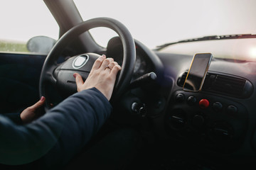 female hand holds the steering wheel of a car. Woman driver concept.