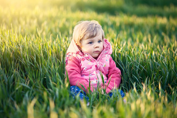 Little girl in the spring grass
