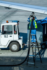 An employee of the ground service of the airport operating the tanker refills the aircraft with aviation fuel.