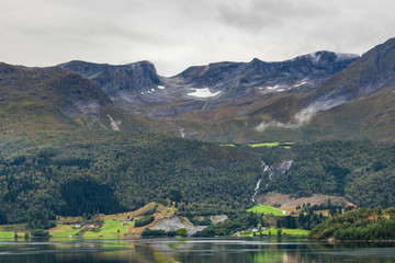 Fototapeta na wymiar Cloudy day in Norway mountains town, lake nature 