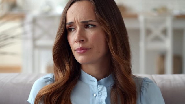 Upset business woman looking on financial diagrams at remote workplace.