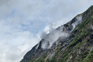 Mystic heavy clouds on green rocky Norway hills 