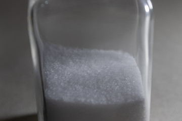 glass shaker bottle half full of salt