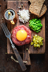Tasty beef tartare with onion, cucumber and chives