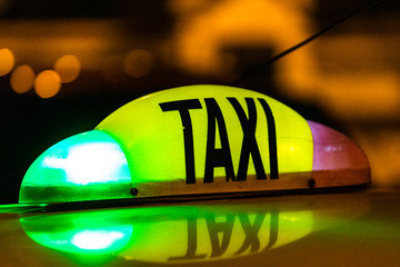Detail of yellow taxi sign on top of a car