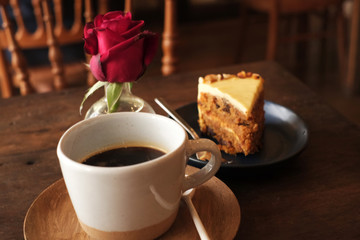 Hot coffee with brown cake and red rose