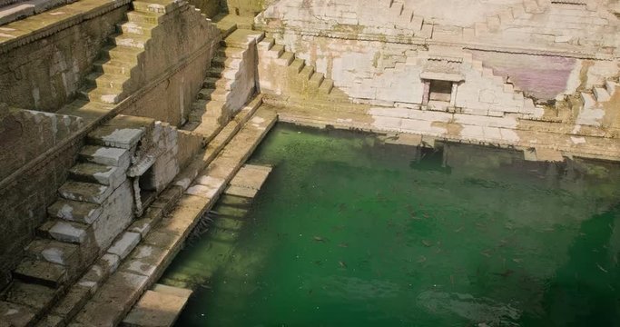 Water storage inside Toorji Ka Jhalra Baoli stepwell - one of water sources in Jodhpur, Rajasthan, India. Vertical pan down to up