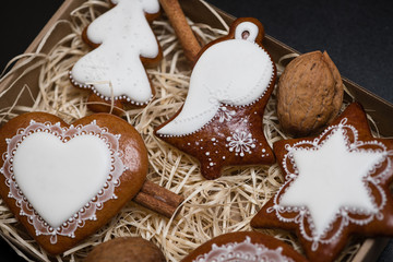 Detail of box with homemade Christmas gingerbread cookies on black background