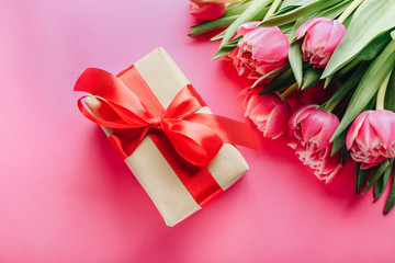 Gift box and bouquet of beautiful tulips on pink background