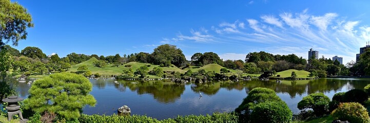 Fototapeta na wymiar ビルに囲まれた街中の日本庭園のパノラマ情景