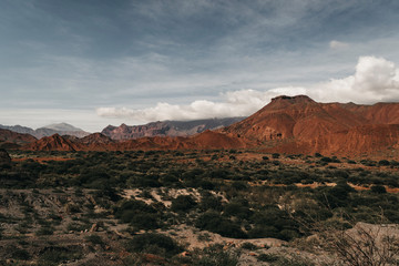 stone formation with a mountain in the background in a cloudy day