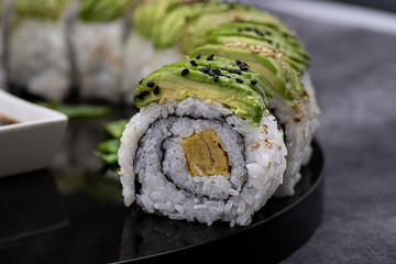 Avocado and omelette sushi on black stone