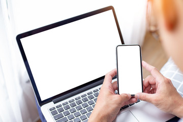 mockup image blank screen computer,cell phone with white background for advertising text,hand man using laptop texting mobile contact business search information on desk in cafe.marketing,design