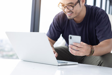 hand holding using texting cell phone and typing computer.businessman at workplace Thinking investment plan.chatting contact Investor.searching for information use internet.connecting people concept