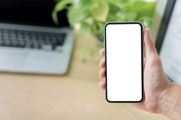 Mockup image blank white screen cell phone.man hand holding texting using mobile on desk at coffee shop.background empty space for advertise text.people contact marketing business,technology 