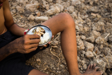 poor child or beggar begging you for help sitting at dirty slum. concept for poverty or hunger...