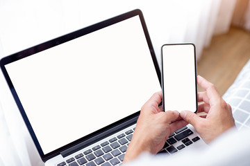 mockup image blank screen computer,cell phone with white background for advertising text,hand man using laptop texting mobile contact business search information on desk in cafe.marketing,design