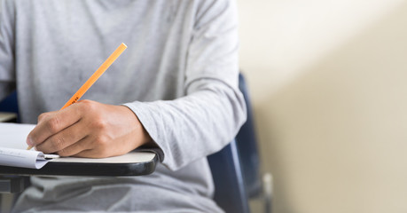 high school,university student study.hands holding pencil writing paper answer sheet.sitting lecture chair taking final exam attending in examination classroom.concept scholarship for education abroad