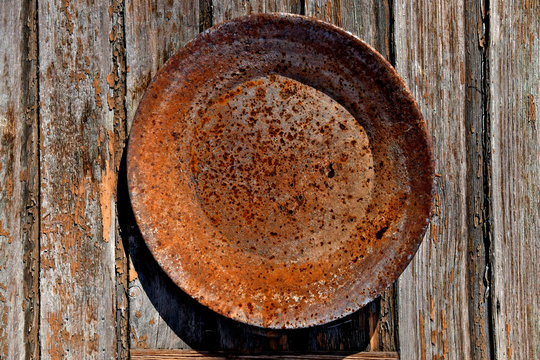 Rusted and pitted gold pan on wooden wall, Huntington, Oregon 