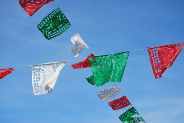 colorful mexican flags in blue sky background