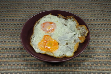 Fried twin chicken egg on the plate. Double crispy fried eggs for breakfast. Easy and quick menu in the morning.