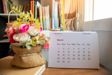 Planner and Calendar Concept.Desktop Calendar 2020,notebook and vase of rose flower placed on office desk in library.