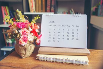 Planner and Calendar Concept.Desktop Calendar 2020,notebook and vase of rose flower placed on office desk in library.