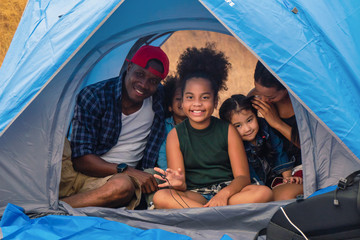 african american family, parent with kids, and asian adoped child having fun together in camping at natural park - Powered by Adobe