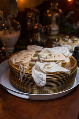 Gold plates and white French lace napkins ready for Christmas dinner