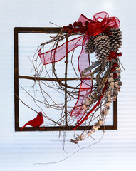 Modern natural holiday decoration with red bow and cardinal