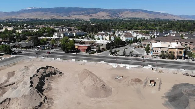 Pan left over hills of fill dirt and construction site across casinos on Virginia street Reno NV