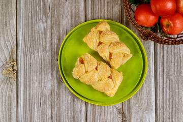 Apple strudel with fresh red apples on wooden table.