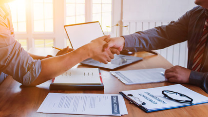 The lawyer is giving legal advice to investors and discussing legal contract documents to be used as a contract between investors signing a consent to invest in doing business together.