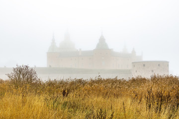Scenic view of Kalmar castle surrounded by heavy mysterious fog. Kalmar, Sweden. © tomalv